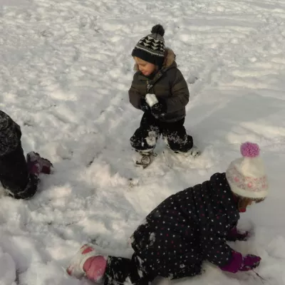 Die Wiesenkinder bauen einen Schneemann